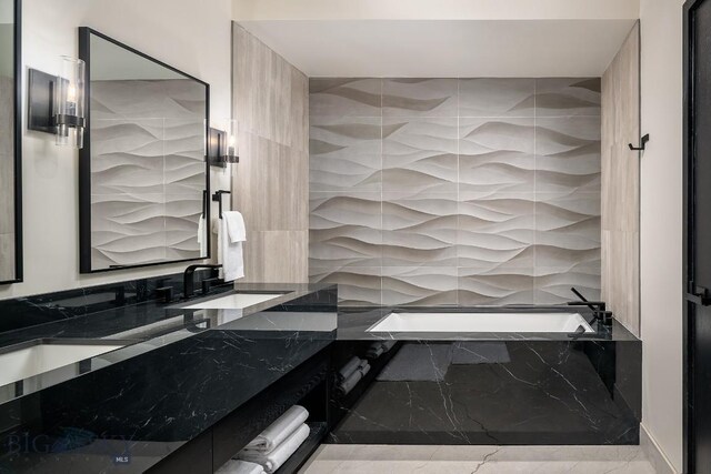 full bath featuring marble finish floor, vanity, and a bath