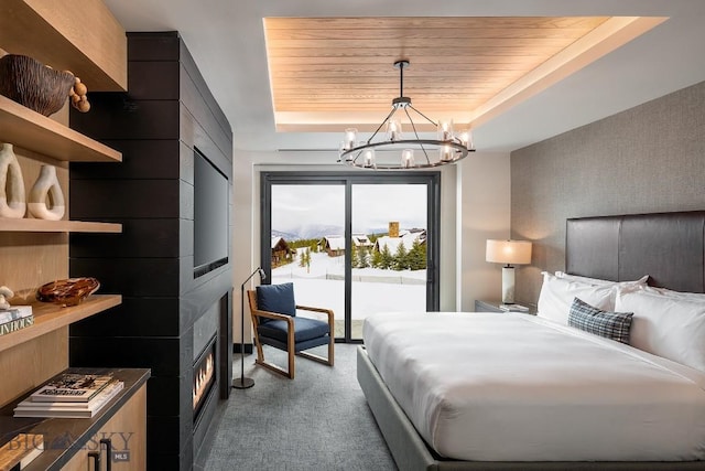 bedroom with wood ceiling, access to exterior, carpet, an inviting chandelier, and a tray ceiling