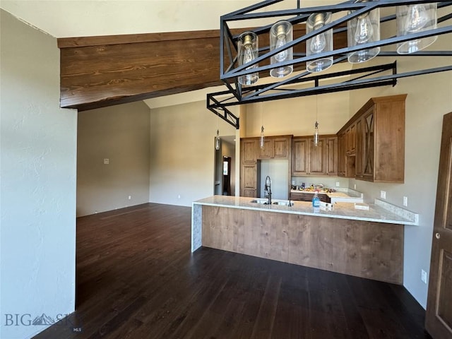 kitchen with dark hardwood / wood-style flooring, light stone countertops, sink, and kitchen peninsula