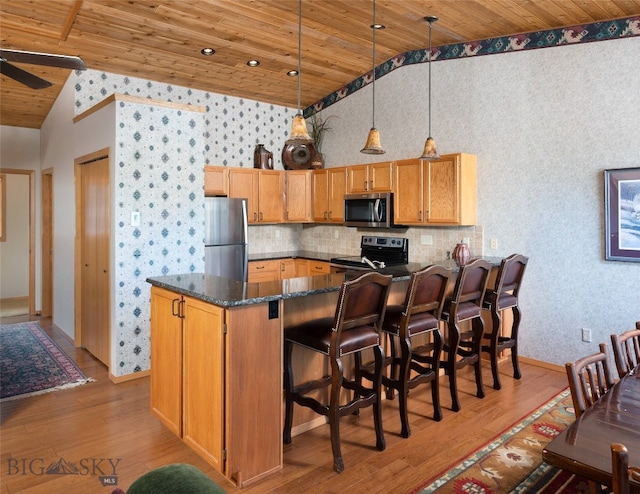 kitchen featuring hanging light fixtures, stainless steel appliances, tasteful backsplash, and wooden ceiling