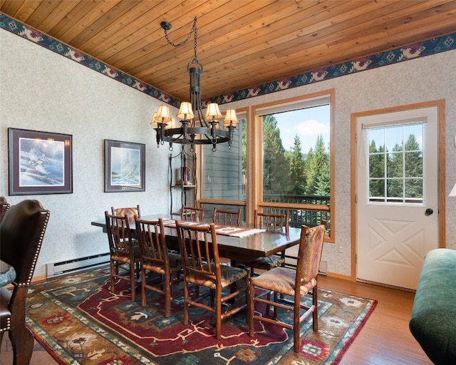 dining space featuring a chandelier, wooden ceiling, light wood-type flooring, and a baseboard heating unit