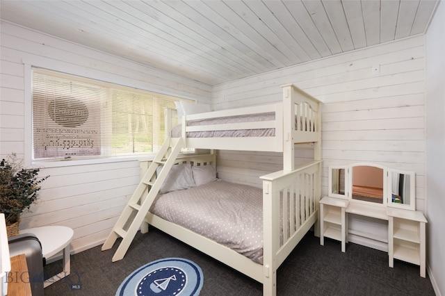 bedroom with wood ceiling, wood walls, and dark colored carpet