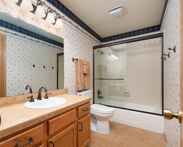 full bathroom with tile floors, bath / shower combo with glass door, toilet, and vanity