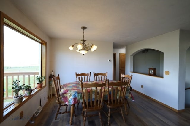 dining area with dark wood-type flooring and a notable chandelier