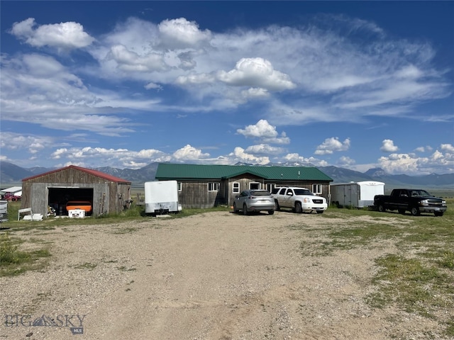 view of side of home with a mountain view, an outdoor structure, and a garage