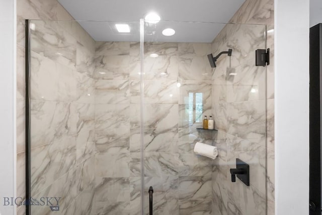 bathroom featuring a shower with shower door