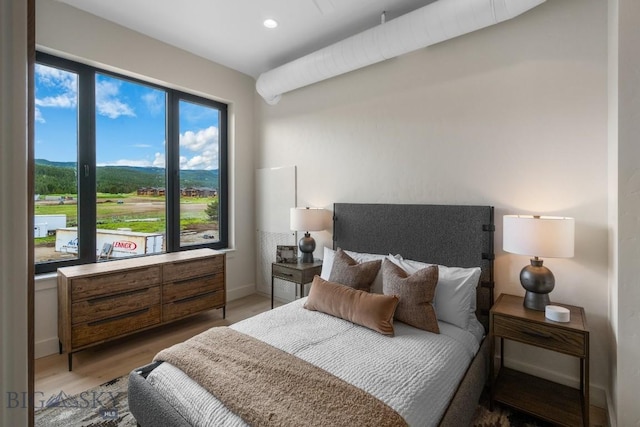 bedroom with hardwood / wood-style flooring and multiple windows