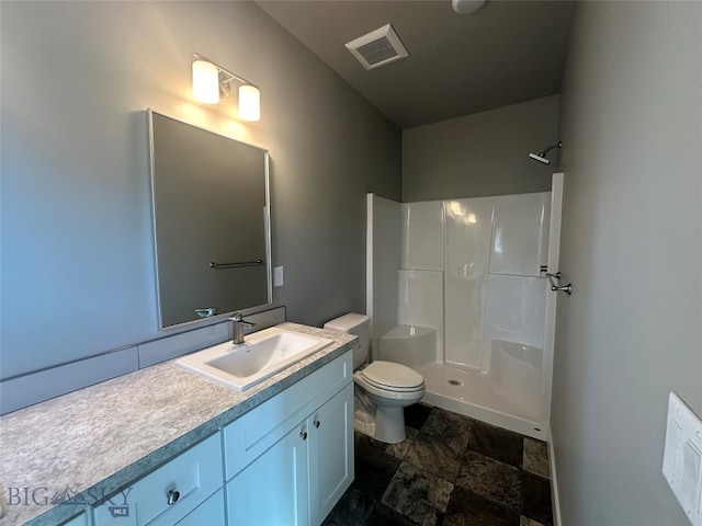 bathroom with toilet, vanity, and walk in shower