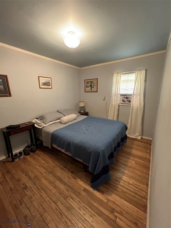 bedroom with ornamental molding and dark wood-type flooring