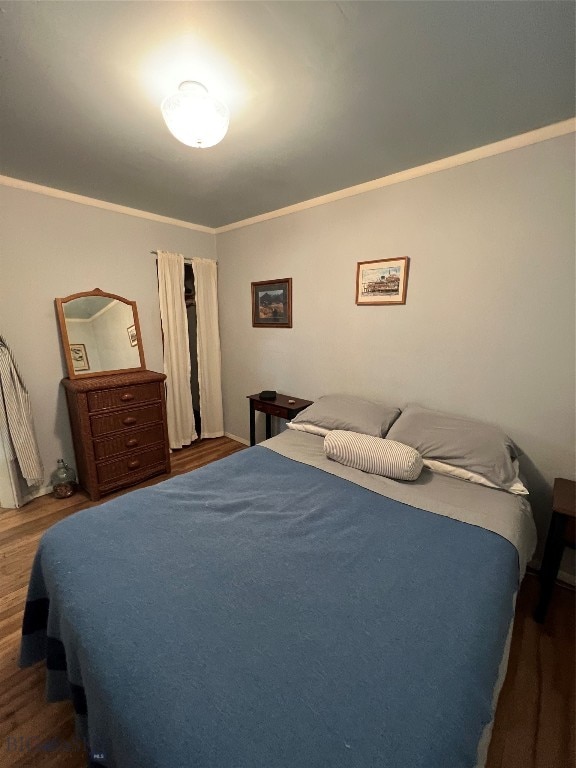 bedroom featuring dark hardwood / wood-style flooring and ornamental molding