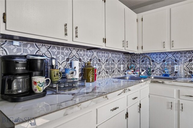 413 E 4th St, Anaconda, MT 59711 - kitchen featuring light stone countertops, backsplash, white cabinetry, and sink