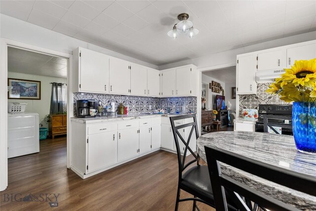 413 E 4th St, Anaconda, MT 59711 - kitchen featuring white cabinetry, washer / dryer, black range with electric stovetop, and exhaust hood