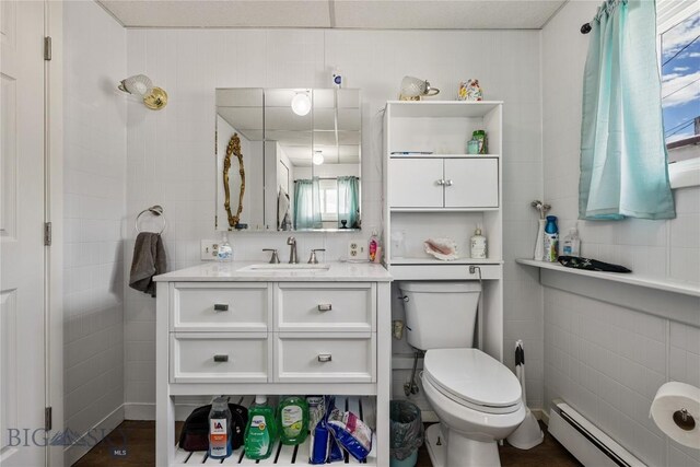 413 E 4th St, Anaconda, MT 59711 - bathroom featuring vanity, toilet, tile walls, and a baseboard radiator