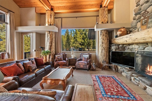 living room with wooden ceiling, beamed ceiling, a fireplace, and a high ceiling