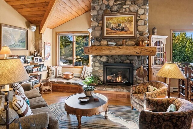 interior space featuring a stone fireplace, wood finished floors, wooden ceiling, and vaulted ceiling