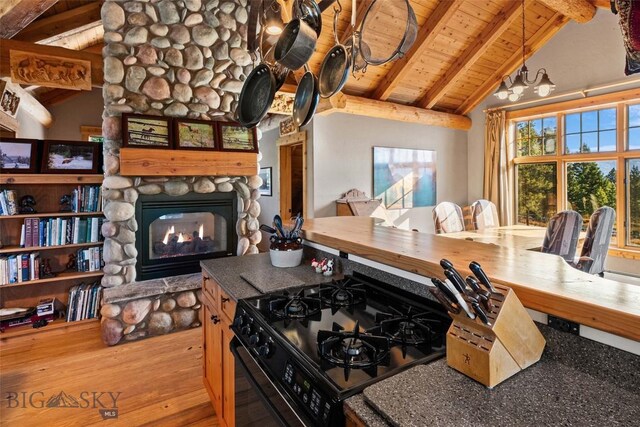 interior space with lofted ceiling with beams, wood ceiling, wood finished floors, and a fireplace