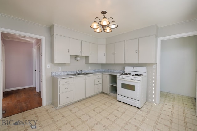 kitchen with white cabinetry, white gas stove, an inviting chandelier, sink, and crown molding