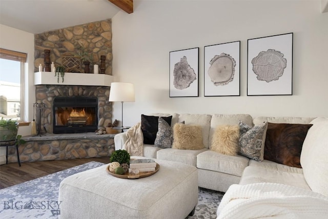 living room with a stone fireplace, vaulted ceiling with beams, and hardwood / wood-style flooring