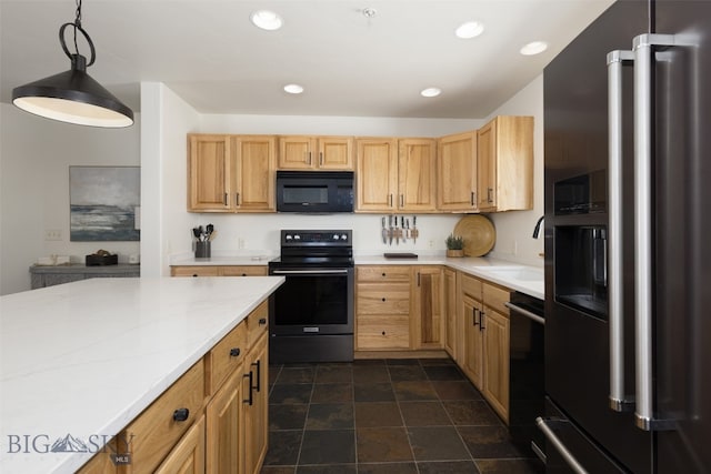 kitchen featuring pendant lighting, light brown cabinets, black appliances, sink, and light stone countertops