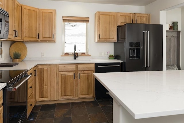 kitchen featuring a sink, stone finish floor, and black appliances