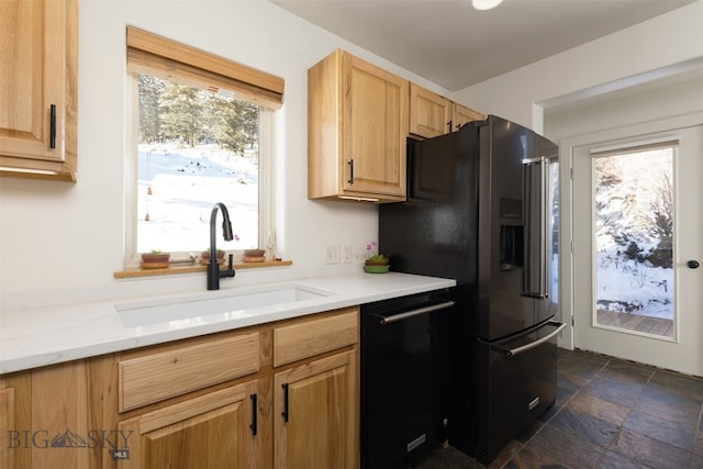 kitchen featuring dishwasher, light brown cabinetry, sink, and stainless steel refrigerator with ice dispenser