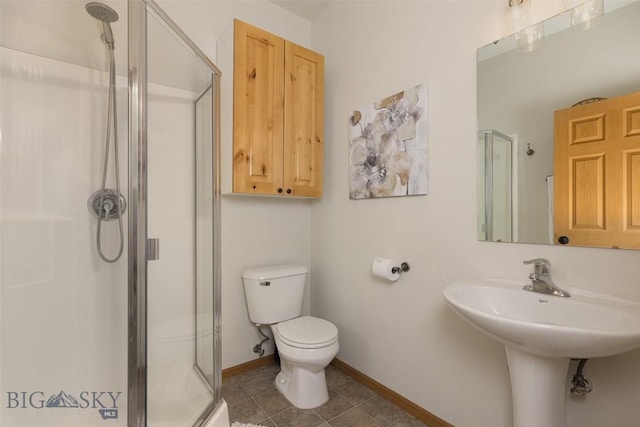 bathroom with baseboards, tile patterned floors, a stall shower, and toilet
