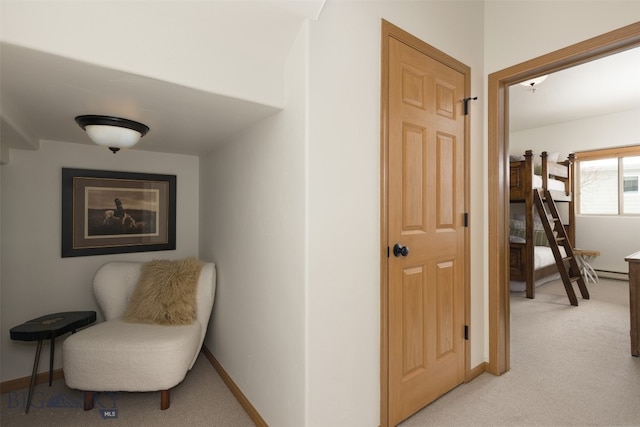 hallway with baseboard heating and light colored carpet