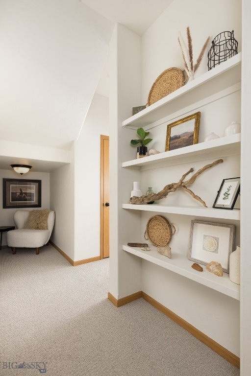 hall featuring lofted ceiling and carpet floors