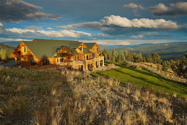 back of house featuring a yard and a mountain view