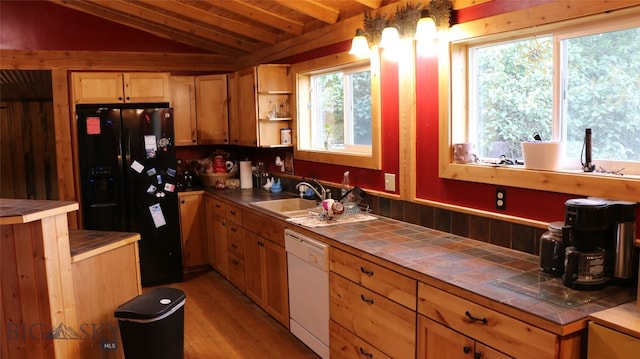 kitchen with white dishwasher, black fridge with ice dispenser, plenty of natural light, and tile counters