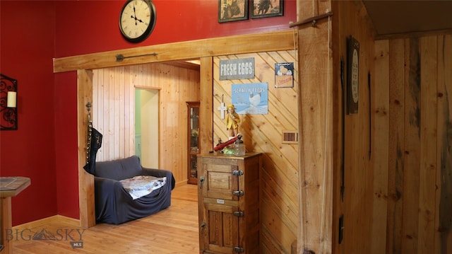 hallway featuring wooden walls and hardwood / wood-style flooring