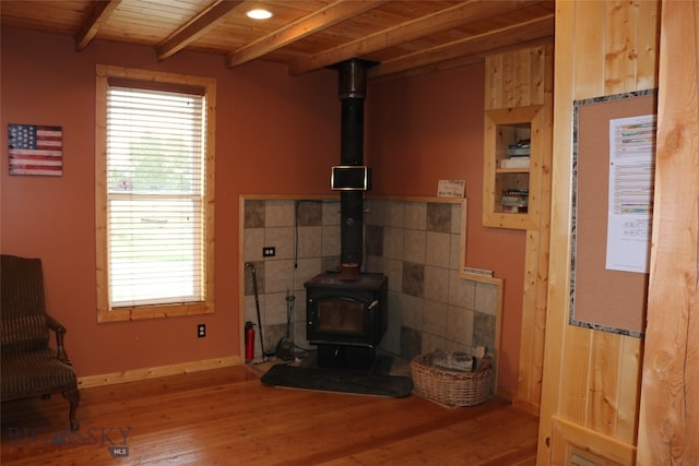 living room with tile walls, a wood stove, beam ceiling, hardwood / wood-style floors, and wooden ceiling