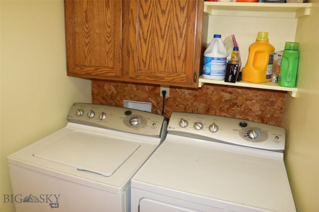 washroom with washing machine and dryer and cabinets