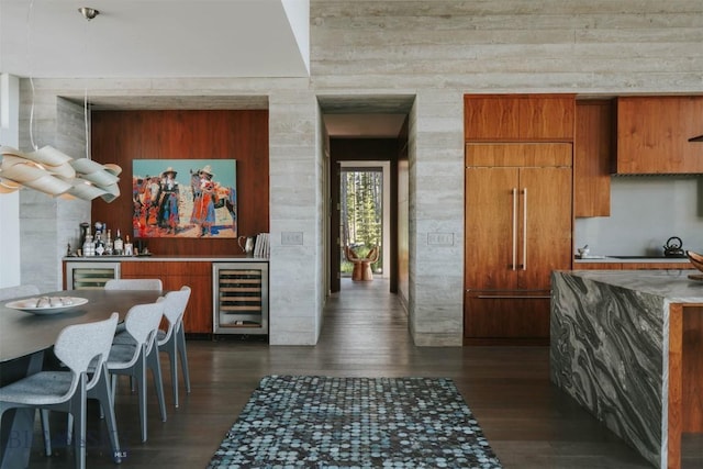 interior space with wine cooler, a dry bar, paneled built in fridge, dark wood-type flooring, and black electric cooktop