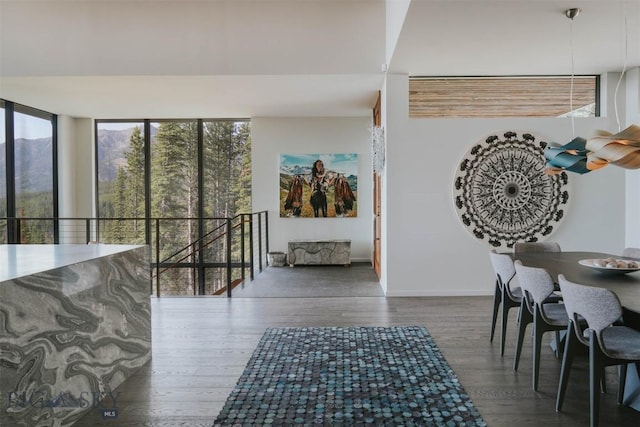 interior space with dark wood-style flooring, baseboards, and an upstairs landing