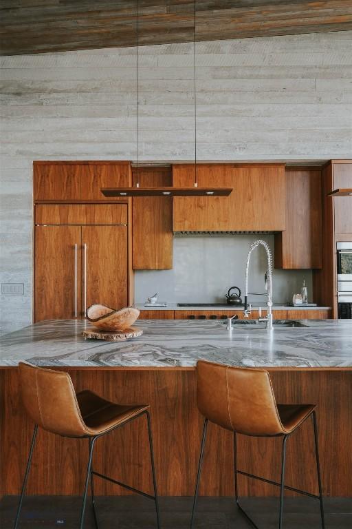 kitchen featuring a breakfast bar, brown cabinets, and modern cabinets