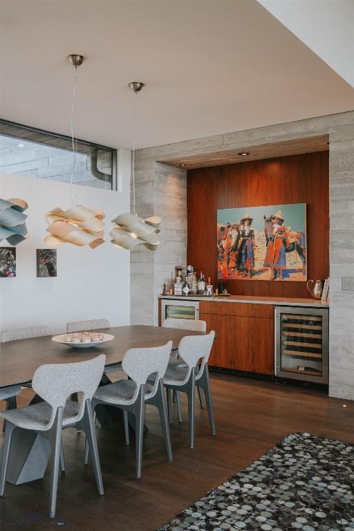 bar featuring hanging light fixtures, beverage cooler, a dry bar, and dark wood-type flooring