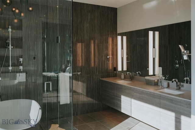 bathroom with tile patterned flooring, a sink, a shower stall, and double vanity