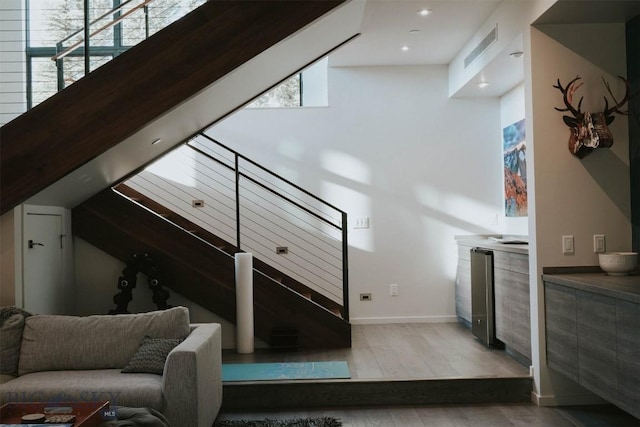 interior space with visible vents, vaulted ceiling, and wood finished floors