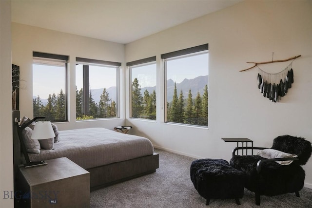 carpeted bedroom with a mountain view and baseboards