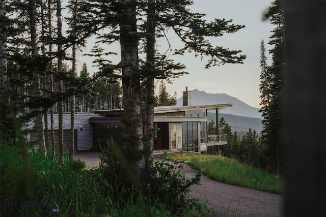 back of property at dusk featuring a mountain view