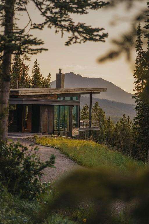 back of property at dusk featuring a chimney and a mountain view