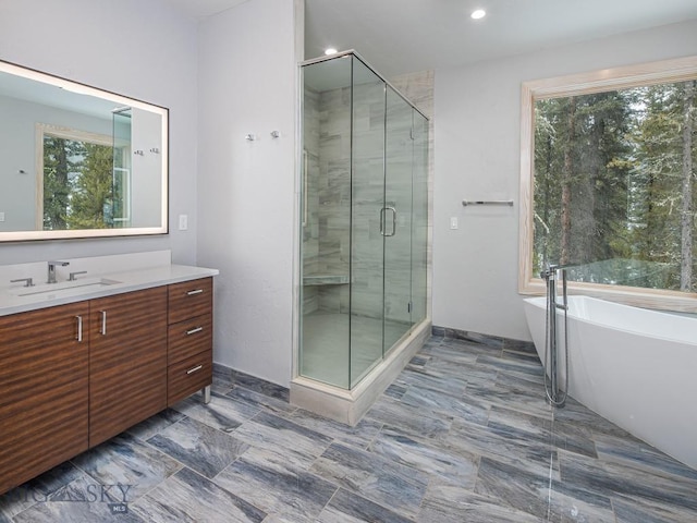 bathroom with vanity, independent shower and bath, and a healthy amount of sunlight