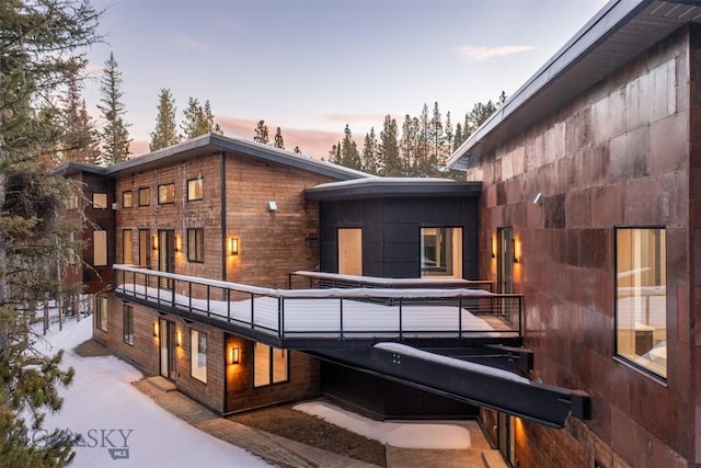 back house at dusk featuring a balcony