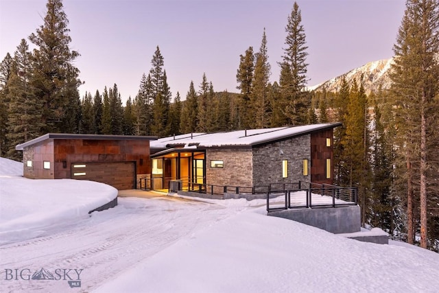 snow covered rear of property featuring a mountain view