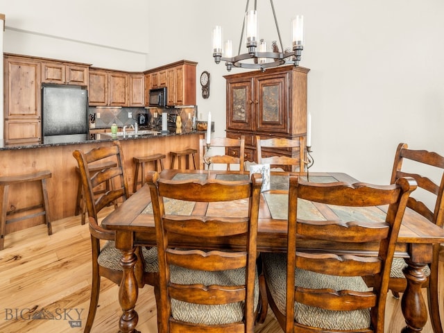 dining space featuring an inviting chandelier and light hardwood / wood-style floors