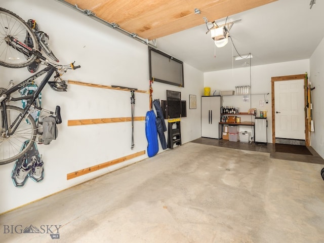 garage with a garage door opener and a workshop area