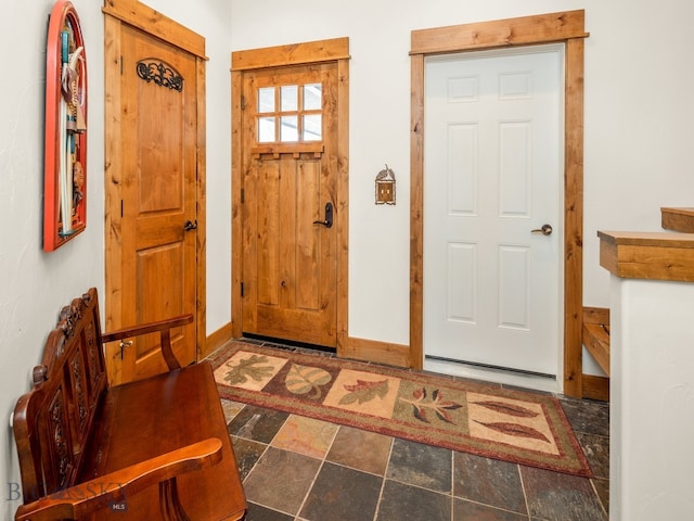 entryway with dark tile floors