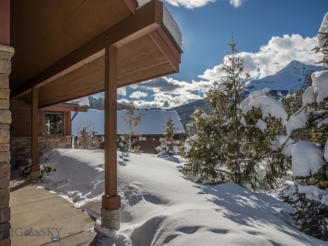 snow covered patio with a mountain view