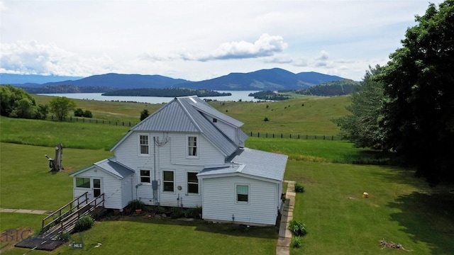 exterior space featuring a rural view, a water and mountain view, and a yard